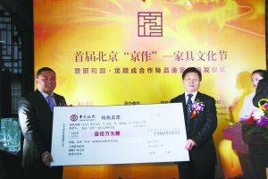 天坛家具拨出100万元设立“京作家具文化保护专项资金”，为“澹宁堂”品牌提供资金支持。图为天坛家具总经理杨金才（右）将支票交给龙顺成经理李勇（左）。