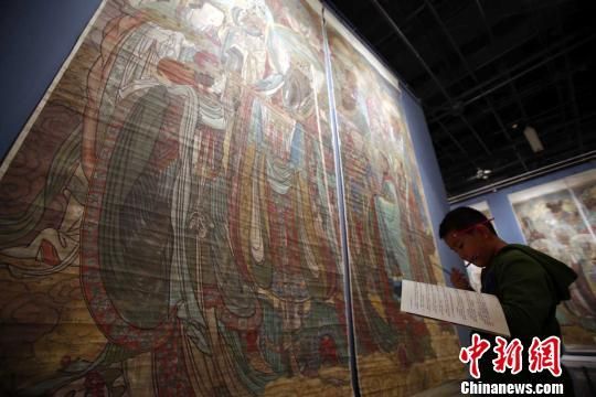 “永乐宫元代壁画临摹作品展”20日在山西博物院开幕，图为一名小学生在画作前临摹。张云摄