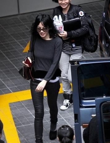 抵达台湾时的王菲身着灰色休闲衫内搭白色打底，下身一款紧腿裤配上高跟鞋，造型很有欧美超模的风范。一款赛琳(Celine)手袋随意挎在肩上很惹眼。
