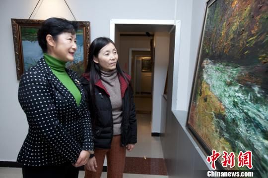 董锦燕主席左一在谢亚丽女士陪同下参观画展