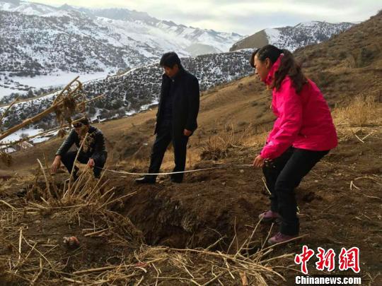 图为工作人员对岩画山体下面的前坡发现一些细小的裂缝进行测绘。　黄万柏 摄