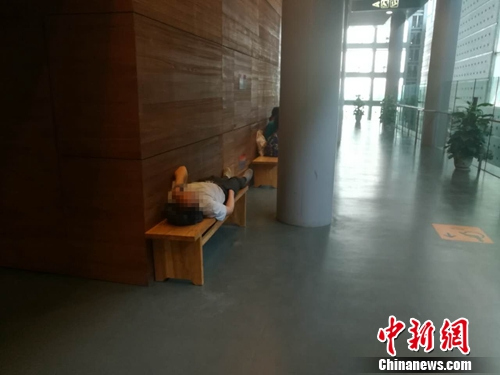 16日，在首博，一名男子躺在长凳上休息。上官云 摄
