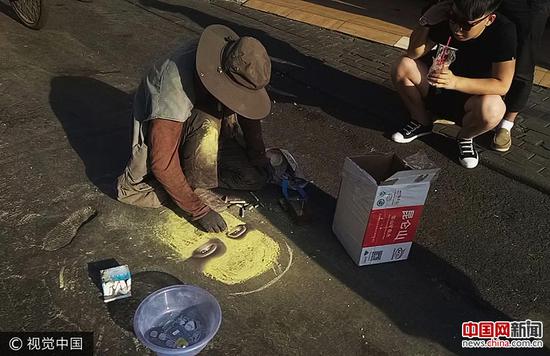 　　2017年5月17日，郑州市彩虹路，一名“流浪画家”在地面上用粉笔作画。