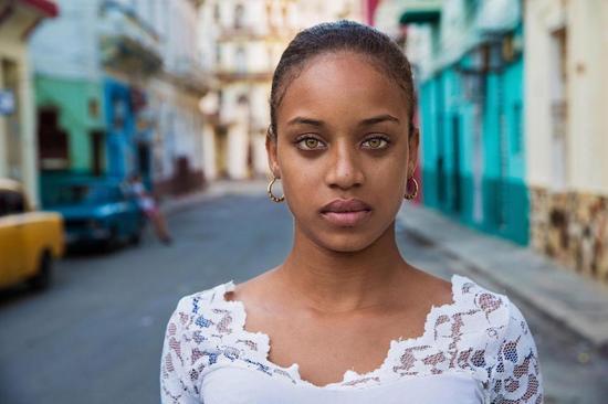在古巴哈瓦那街头，她的相机留下了这个年轻美女的照片。