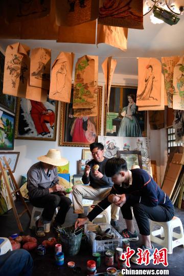 图为刘海(右二)和家人在家中画土豆 刘冉阳 摄