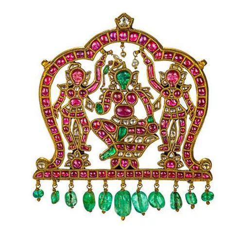 在这件精美的吊坠上，印度教克利须那神的两侧是他的两位妻子，鲁格米尼和萨缇亚芭玛。三张面孔均采用祖母绿和红宝石雕刻而成，22K 黄金，南印度 ? 20 世纪初。