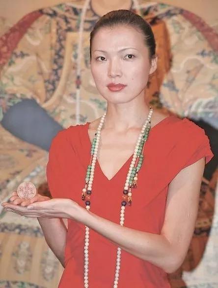 模特儿在香港苏富比2010年春季拍卖上，戴着成交价破纪录的“清雍正御制东珠朝珠”及手捧“清乾隆帝御宝题诗‘太上皇帝’白玉圆玺”。