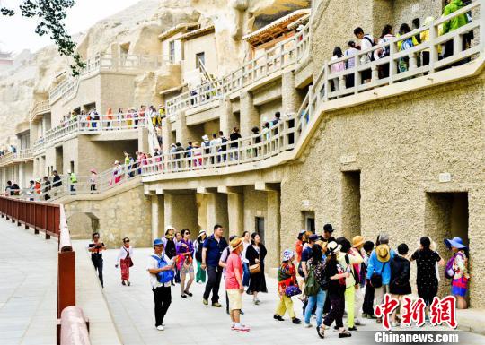 资料图：丝绸之路上的国际旅游名城甘肃敦煌迎来了传统旅游旺季，敦煌莫高窟游人如织。　王斌银　摄