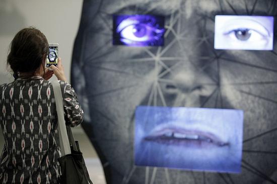 参观者用手机记录艺术家Tony Oursler的作品。图片：by Michele Tantussi/Getty Images