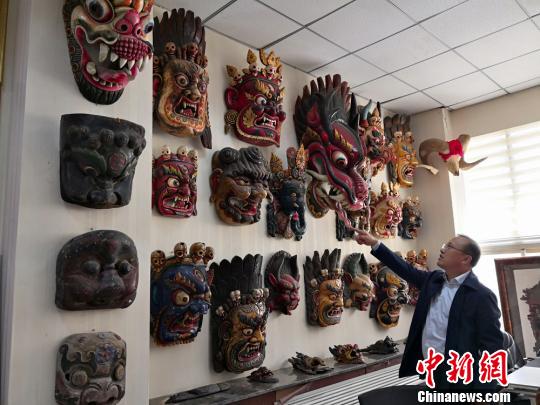 图为贾森栋和他收藏的傩面具。　刘薛梅　摄