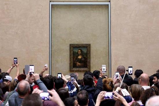 法国卢浮宫《蒙娜丽莎》前举着手机拍摄的观众