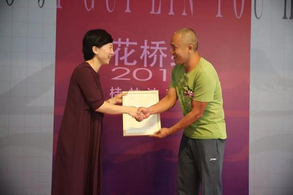 桂林市花桥美术馆馆长邱丽萍向参展艺术家代表谢宗波颁发收藏证书。