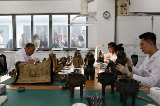 预约观众隔着玻璃观看“文物医生”修文物。新京报记者 浦峰 摄