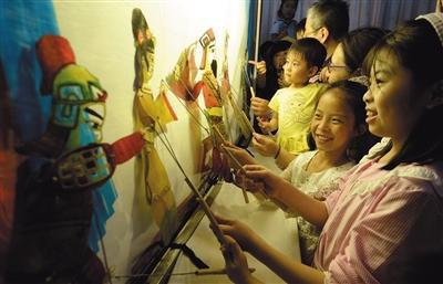 昨日，邯郸博物馆，小朋友们体验皮影戏表演。图/视觉中国