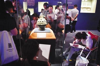 6月8日，首都博物馆，展厅内，学生在对南北朝时期的青瓷莲花尊进行写生。