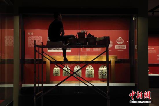 图为7月7日山西青铜博物馆工作人员正在进行灯光布置。中新社记者 张云 摄