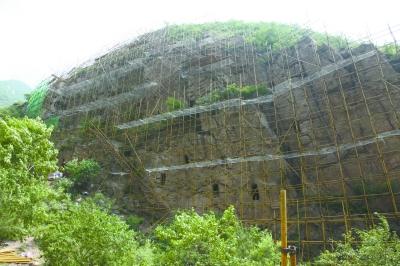 姚家营洞穴遗址近日启动修缮，崖壁外侧搭建起高48米、宽130米的脚手架。延庆区文委供图